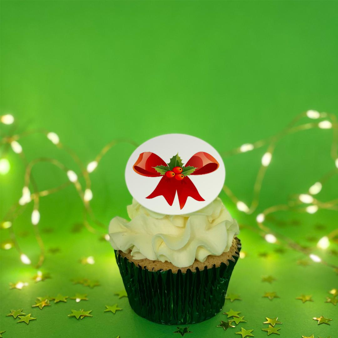 Christmas cupcake with a red ribbon and holly printed topper